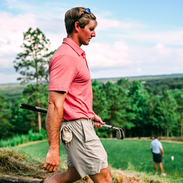 Man in red shirt holding golf clubs