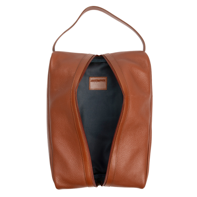 A brown pebbled leather zippered pouch with a top handle, shown open to reveal a dark navy interior. A small brown leather brand label is visible inside.