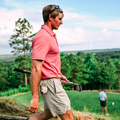 Man in red shirt holding golf clubs