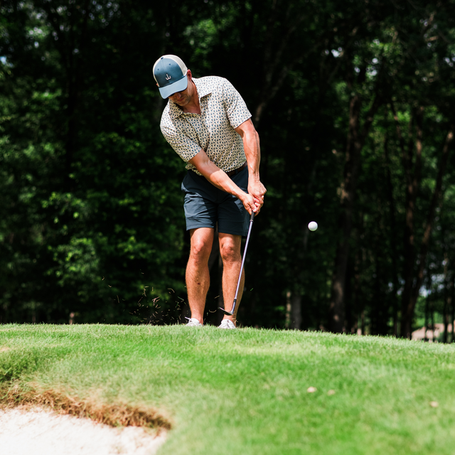 Golfer chipping on the green in the summer