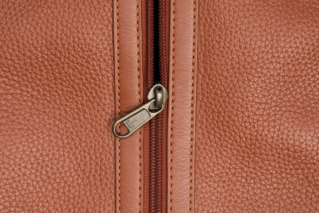 Close-up of a brown leather bag with a zipper