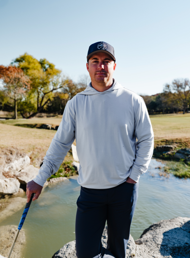 Golfer in front of water winter golf gray hoodie