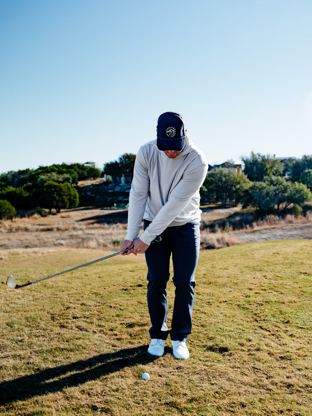 Golfer chipping in gray hoodie