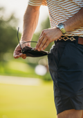 Man wiping sunglasses on shorts cleaner